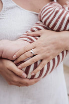 Mother wearing a breastmilk ring holding a baby - breastmilk jewellery